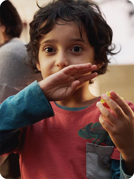 young boy smiling and eating an apple as an example of images you can send in whatsapp